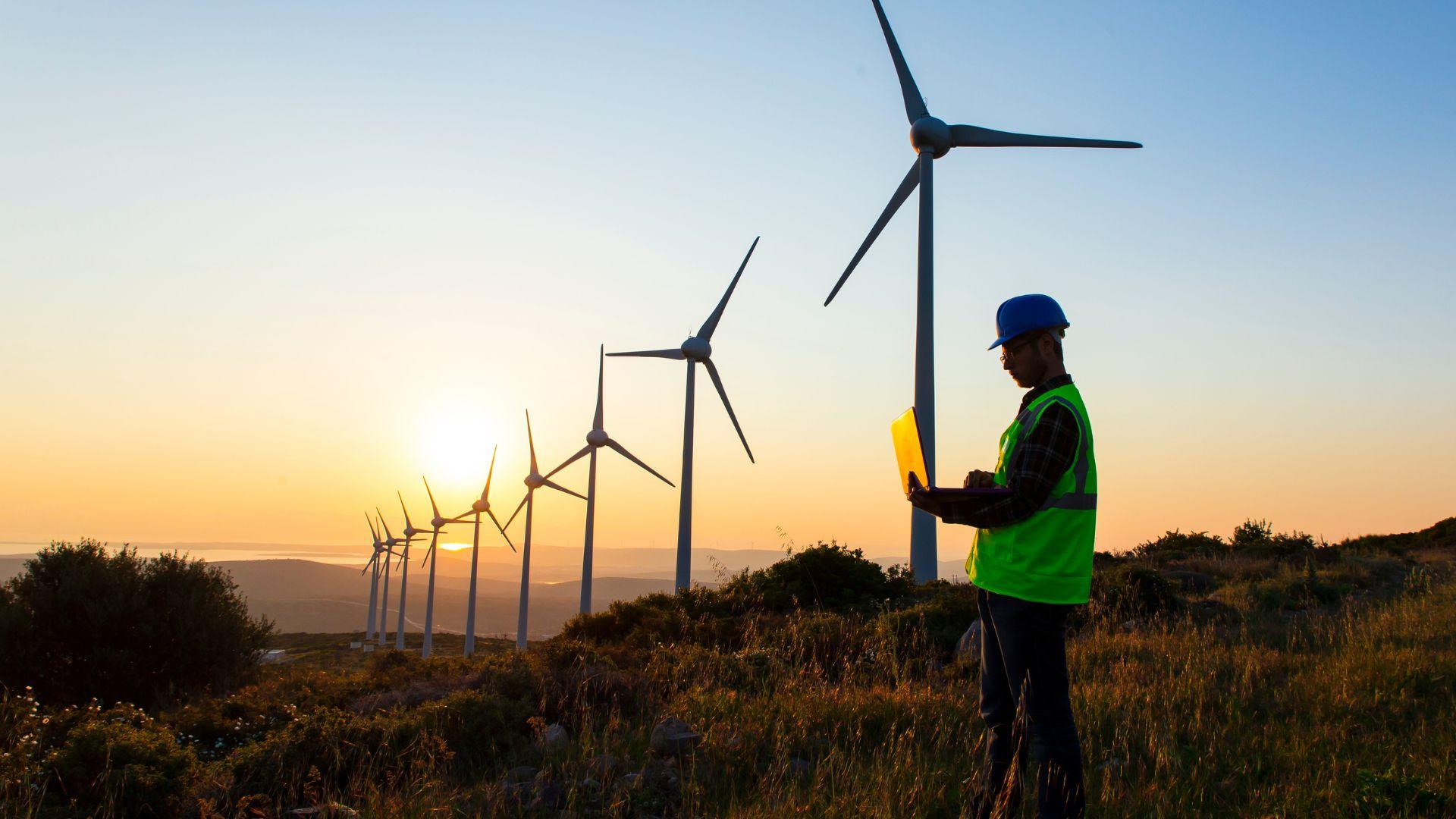 Wind turbines with sun in the background.