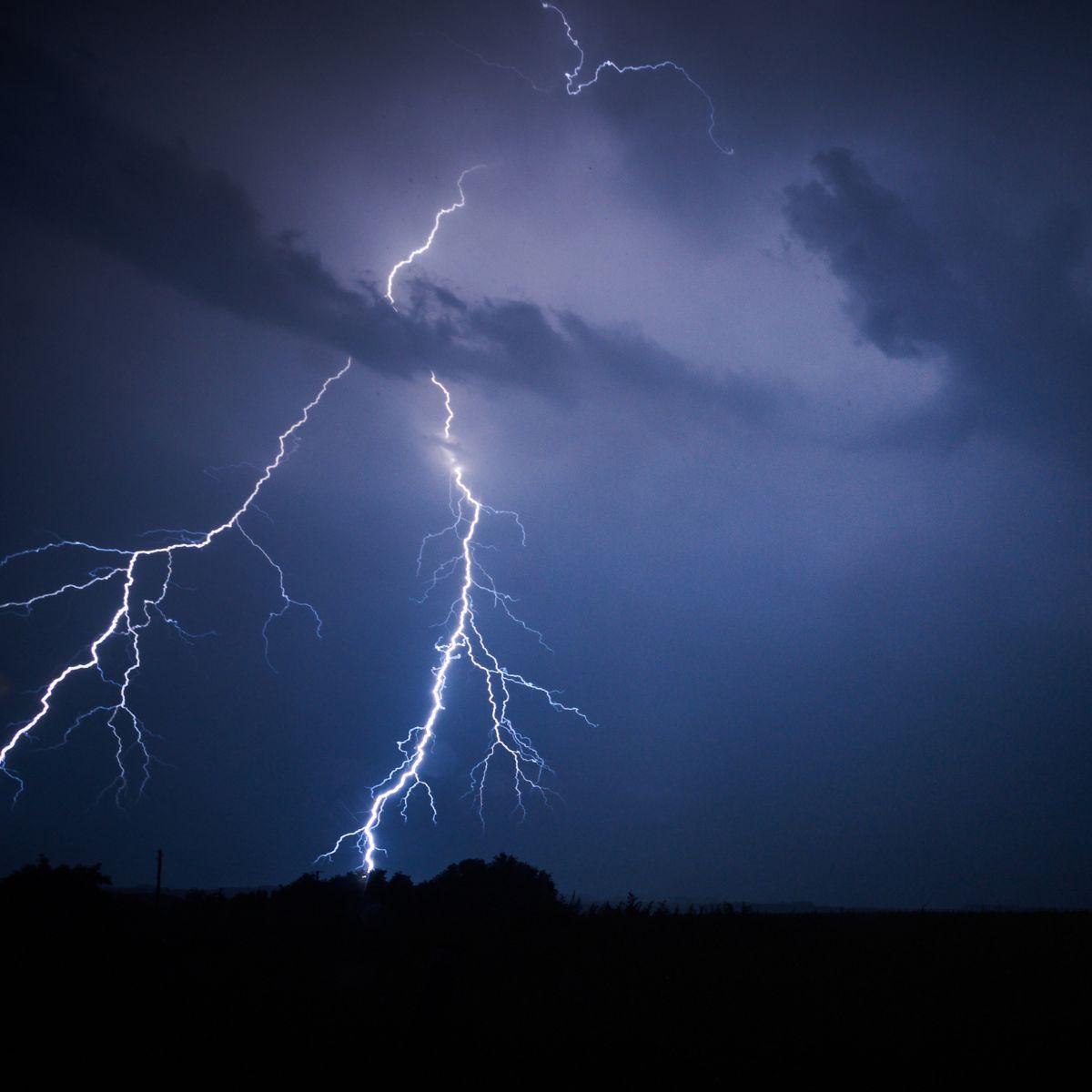 Lightning strike with two strokes and a dark blue sky.