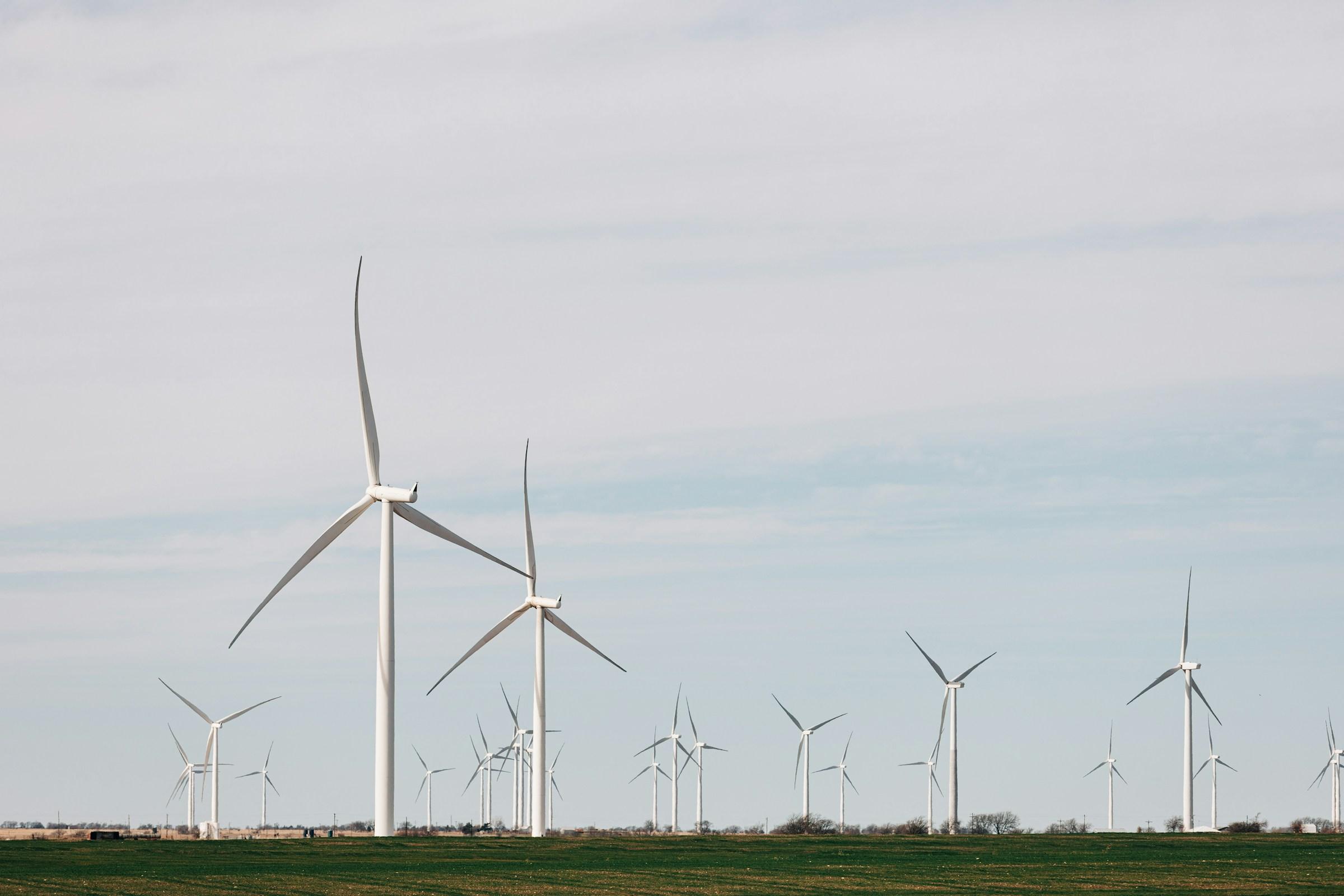Wind turbines standing on field under a clowdy sky