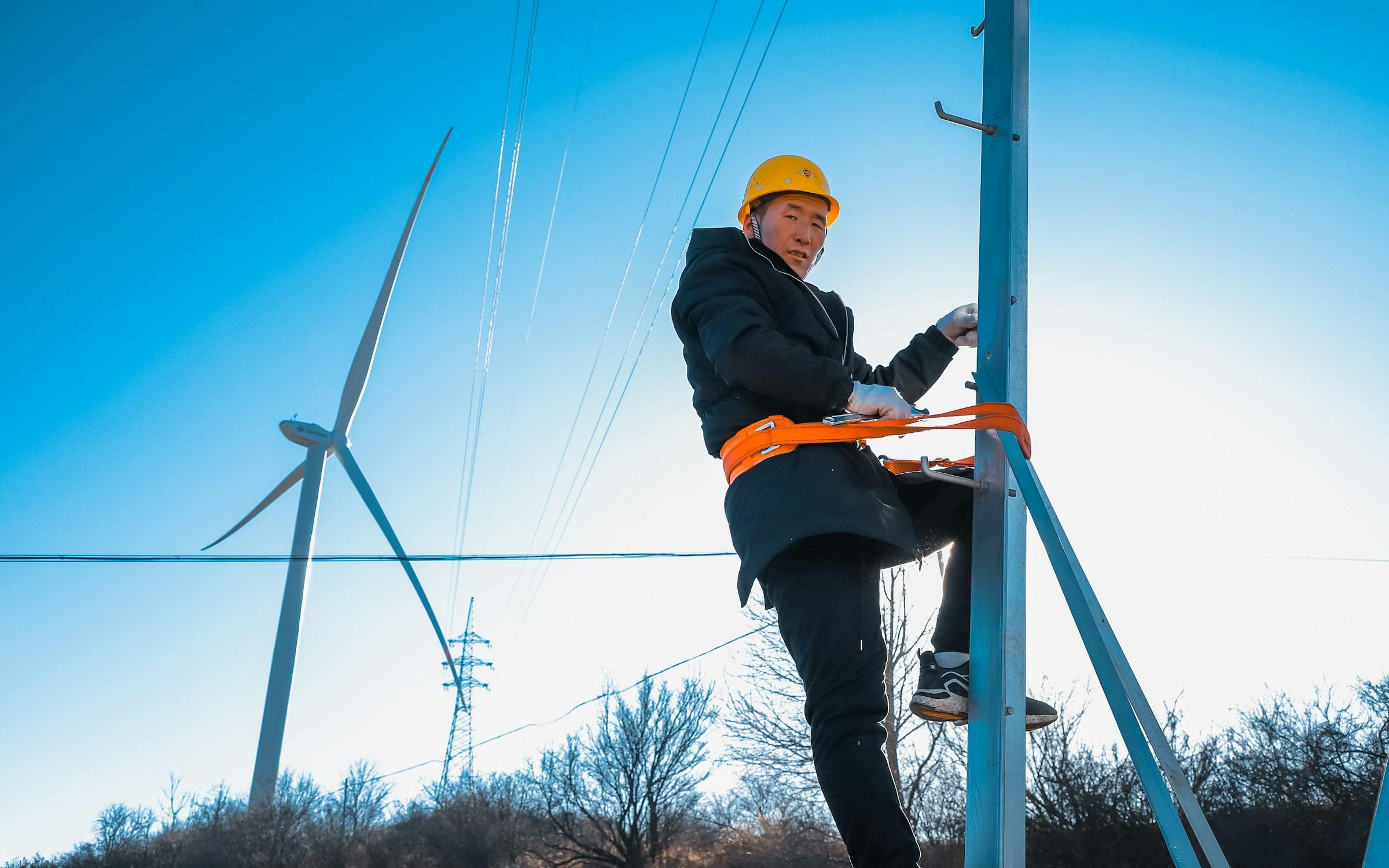 Wind turbine technician in safety gear preparing a rotor blade inspection