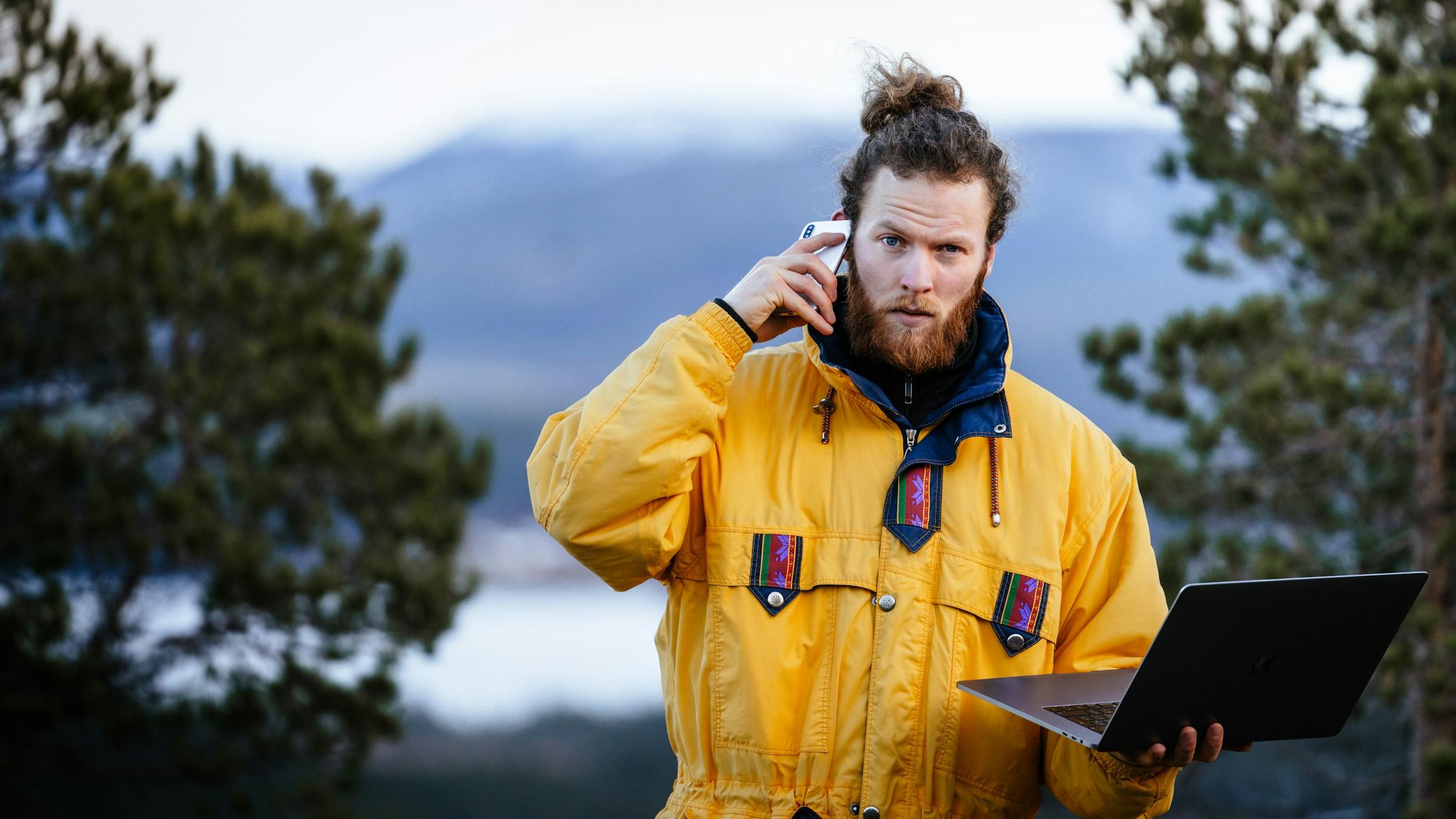 Wind farm engineer reviewing turbine data on a laptop in the field